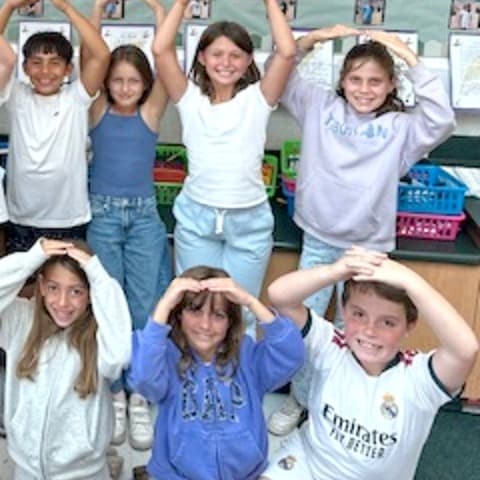 More Reed students making the letter O with their arms.